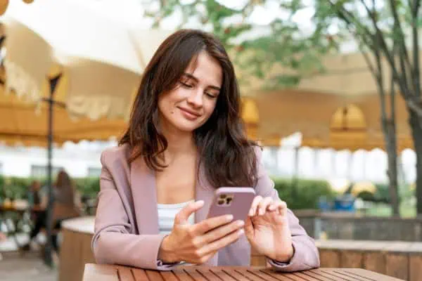 Woman scrolling phone medium shot